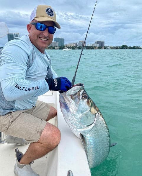 Captain David Cohen holding a tarpon on his boat in Miami